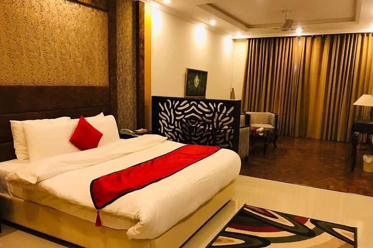 Una habitación de hotel con una cama grande, un escritorio y una silla.