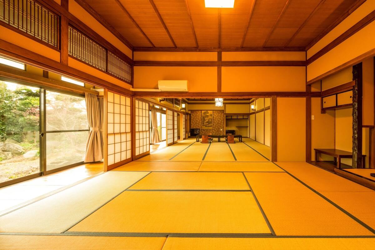 Une pièce de style japonais traditionnel, avec un sol recouvert de tatamis, des portes coulissantes et un plafond en bois.