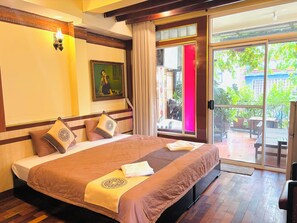 A hotel room with a large bed, a painting on the wall, and a sliding glass door leading to an outdoor area. - Bi Saigon Hotel (Ho Chi Minh City)