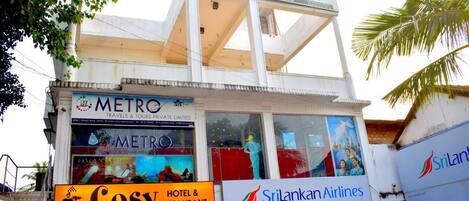 Un hotel chiamato 'Cosy' con una insegna per 'SriLankan Airlines' e un'insegna per 'Metro Travels & Tours Private Limited'.