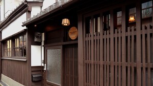 A traditional wooden building with a large wooden door and windows.