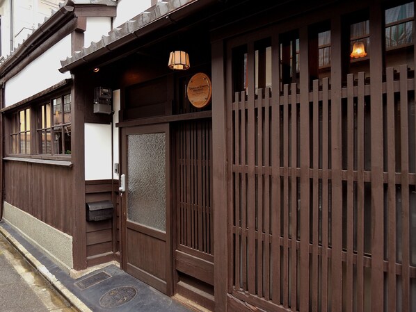 Un bâtiment traditionnel en bois, doté d’une grande porte et de fenêtres en bois.