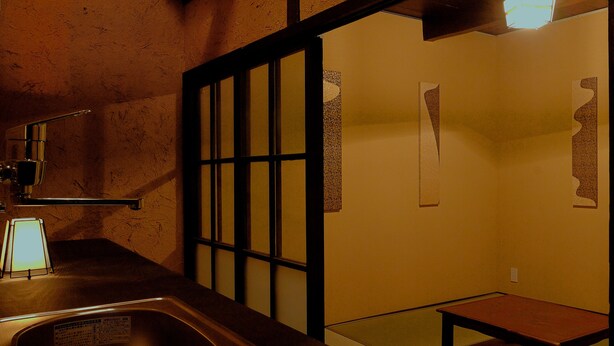 A bathroom with a sink, mirror, and a small bench.