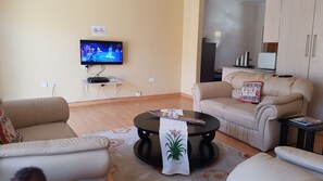 Apartamento, 2 habitaciones | Zona de estar | Una televisión de pantalla plana, un reproductor de DVD
