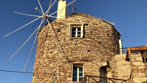 A stone windmill attached to a building with a small window and a door. - The Stone Windmill (Kea)