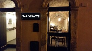 An interior view of a restaurant with stone walls and a sign above the entrance. - Iblainsuite (Ragusa)