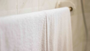 A white towel hanging on a bathroom wall. - Lolos Elegant Three Bedroom Apartment (Harare)