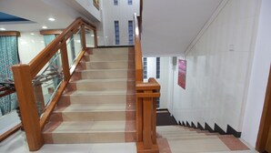 Un escalier avec des rampes et une main courante en bois, menant à l’étage supérieur.