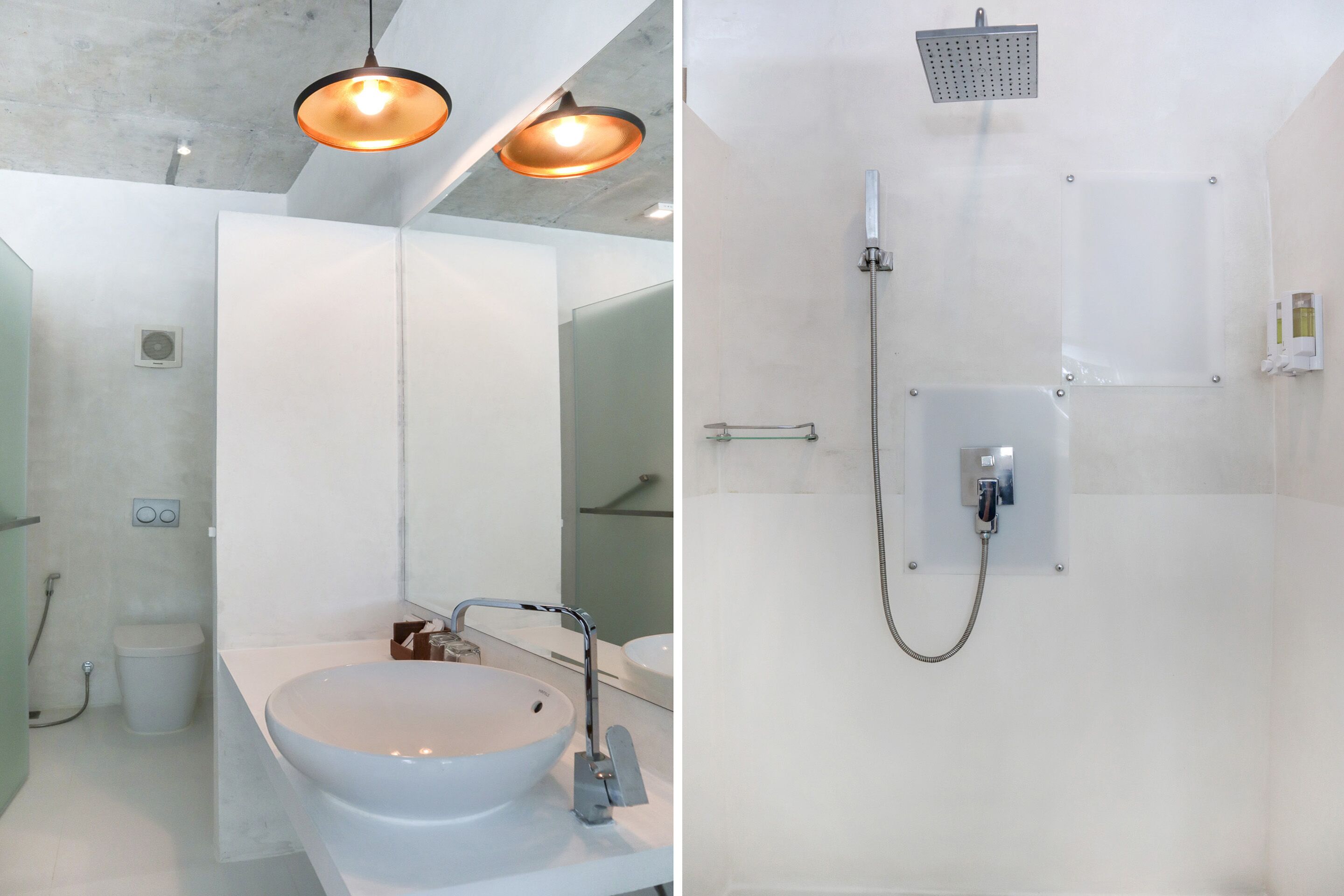 A modern bathroom with a large white sink, a mirror, and a shower with a handheld showerhead.