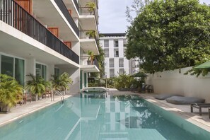 A swimming pool with a clear blue water surface, surrounded by potted plants and outdoor seating. - Wabi Sabi Boutique Hotel (Kamala)