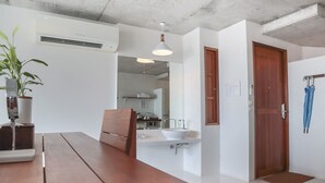 A modern kitchen with a wooden table, a sink, and a hanging plant.