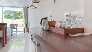 A modern kitchen with a wooden countertop, a coffee maker, and glassware.