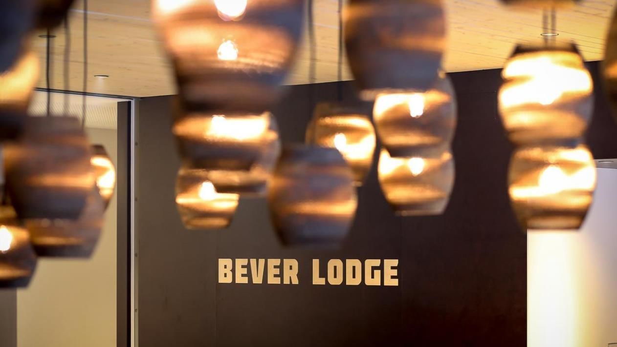 Un interior moderno con lámparas colgantes y una pared con el texto "BEVER LODGE".