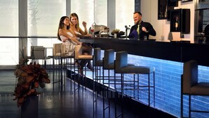 A bar area with high stools, a counter, and a large window. - Hotel Aquacity Riverside (Poprad)