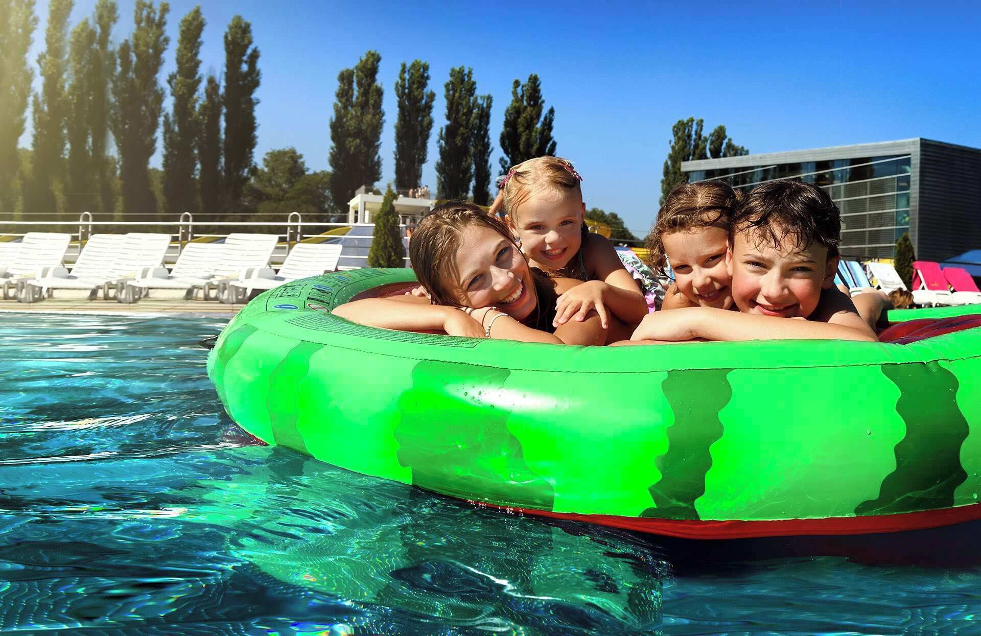 A swimming pool with a green inflatable raft.