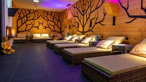 A spa room with four wicker beds, a Buddha statue, and a wall mural. - Hotel Aquacity Riverside (Poprad)