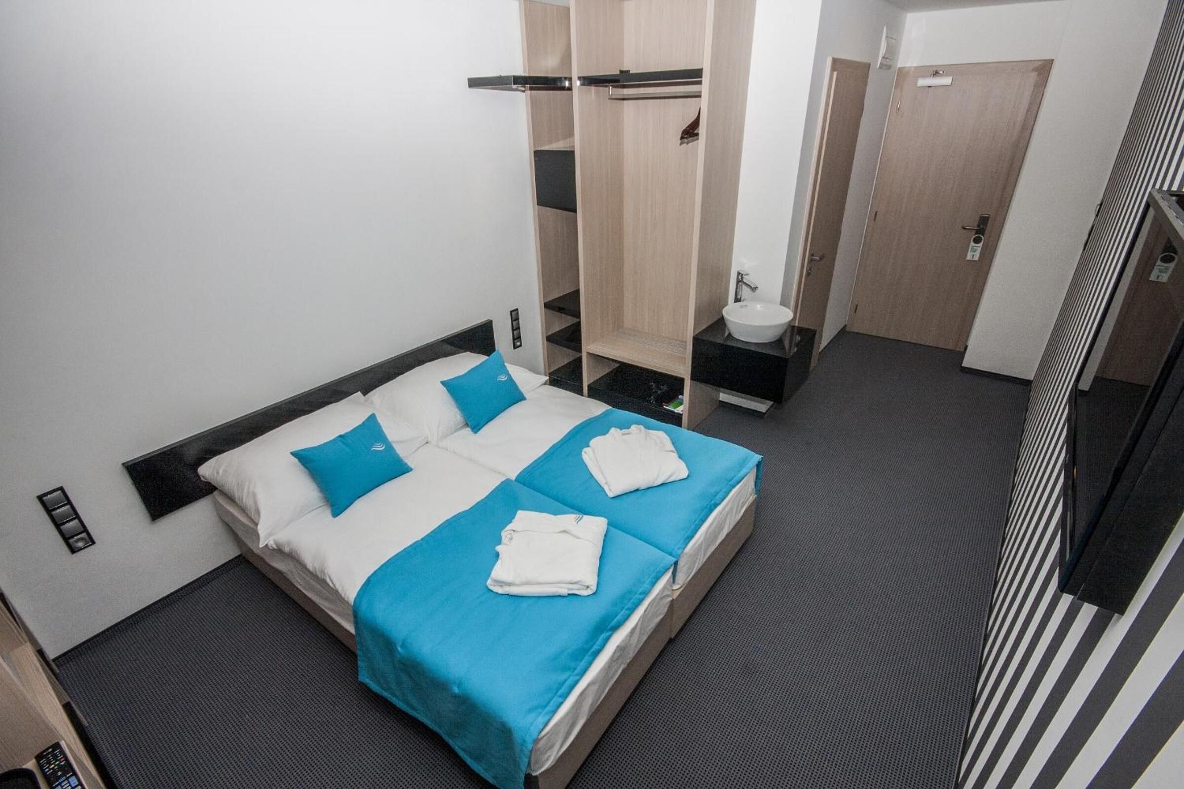 Ein Hotelzimmer mit Bett, Badezimmer und Kleiderschrank.
