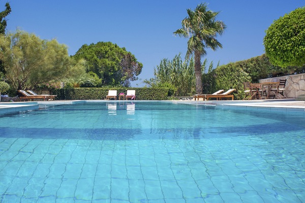 Una piscina al aire libre, sillones reclinables de piscina