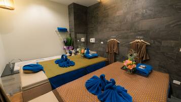 Relax in a stylishly designed room with a neatly arranged bed, a small table, and a wall-mounted towel rack.