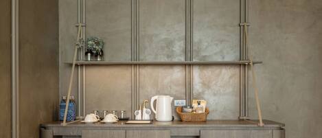A kitchenette with a built-in stove, a coffee maker, and a kettle on the counter.