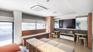 Un interior moderno con una zona de estar, un televisor de pantalla plana y una pared decorada con ladrillo.