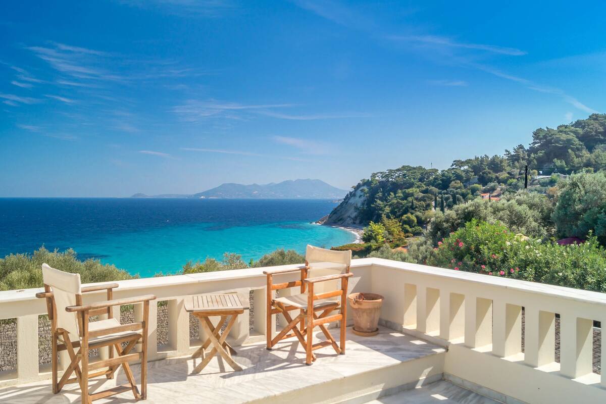 Una terraza con vista al mar y a un paisaje montañoso.