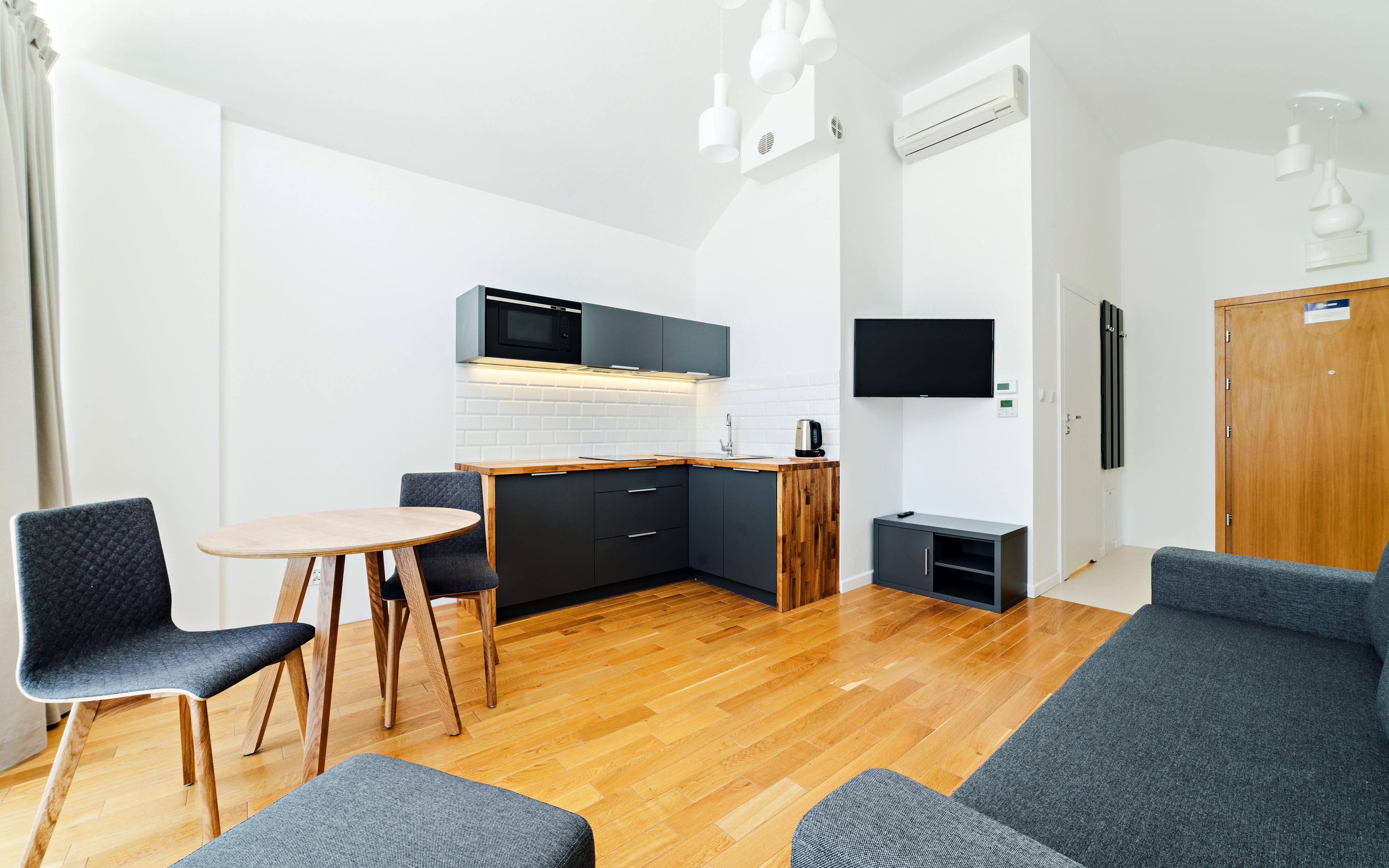 En kompakt bolig med et tekøkken, et spiseområde og en siddeplads.