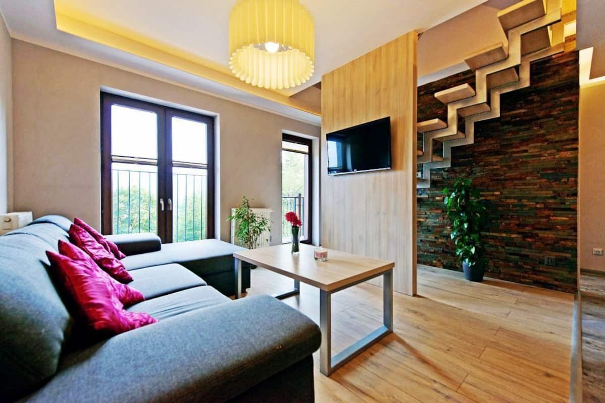 Ein modernes Wohnzimmer mit einer Couch, einem Couchtisch und einer Treppe mit einem außergewöhnlichen Design.