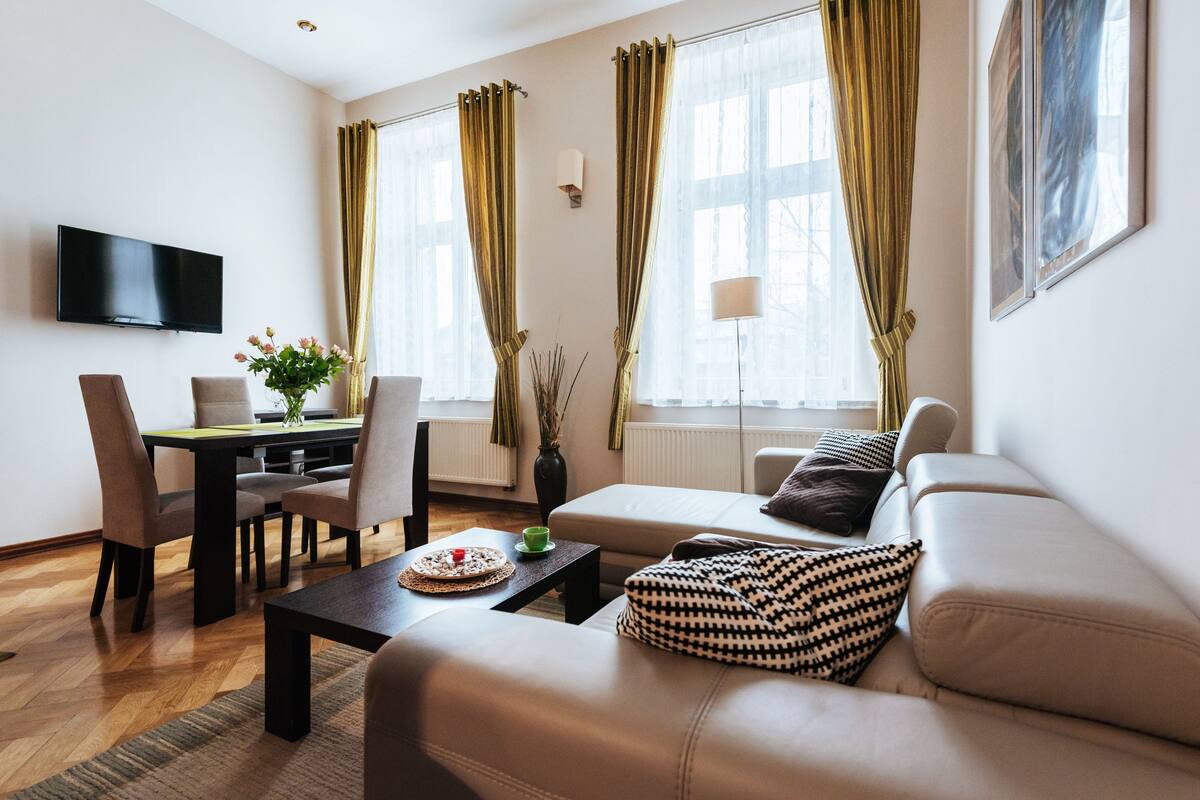 Ein modernes Wohnzimmer mit Sofa, Couchtisch und Essbereich.