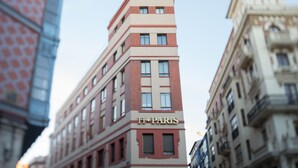 Um edifício com uma placa que diz "FI. PARIS" no nível da rua.