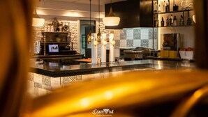 A modern kitchen with pendant lighting, a television, and a wine rack. - Hotel Ínsula Barataria (Alcazar de San Juan)