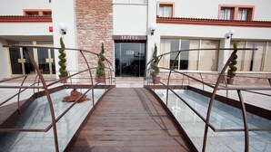 A hotel entrance with a metal staircase leading up to a glass door. - Hotel Ínsula Barataria (Alcazar de San Juan)