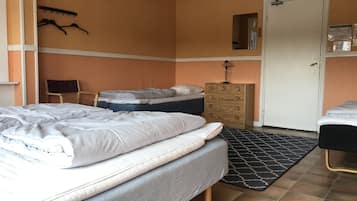 A bedroom with a bed, a dresser, a chair, and a door.