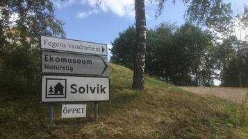 Señal direccional con flechas indicando 'Fegens vandrarhem', 'Ekomuseum Naturstig' y 'Solvik'.