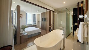 Un baño moderno con una bañera independiente, un recinto de ducha de vidrio y un espejo grande.
