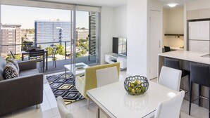 Un appartement moderne doté d’un balcon, d’un coin repas et d’une cuisine.