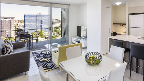 Un appartamento moderno con balcone, zona pranzo e cucina.