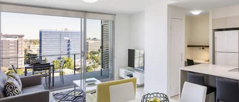 A modern apartment with a balcony, a dining area, and a kitchen.