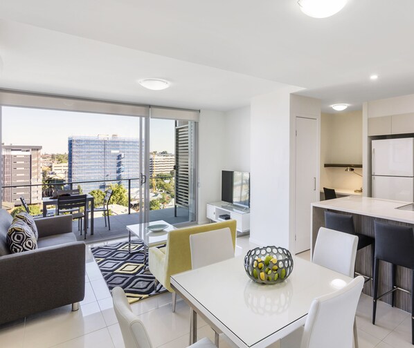 Un appartamento moderno con balcone, zona pranzo e cucina.