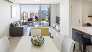 Un salon moderne avec un canapé, une table à manger et un téléviseur.