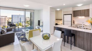 Un appartement moderne doté d’un balcon, d’un coin repas et d’une cuisine.