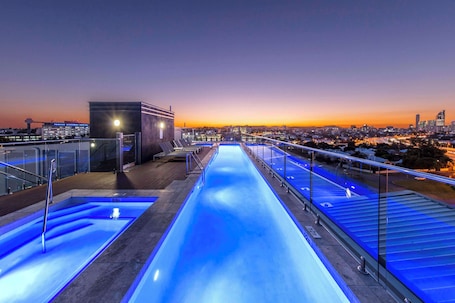Una piscina al aire libre, sillones reclinables de piscina