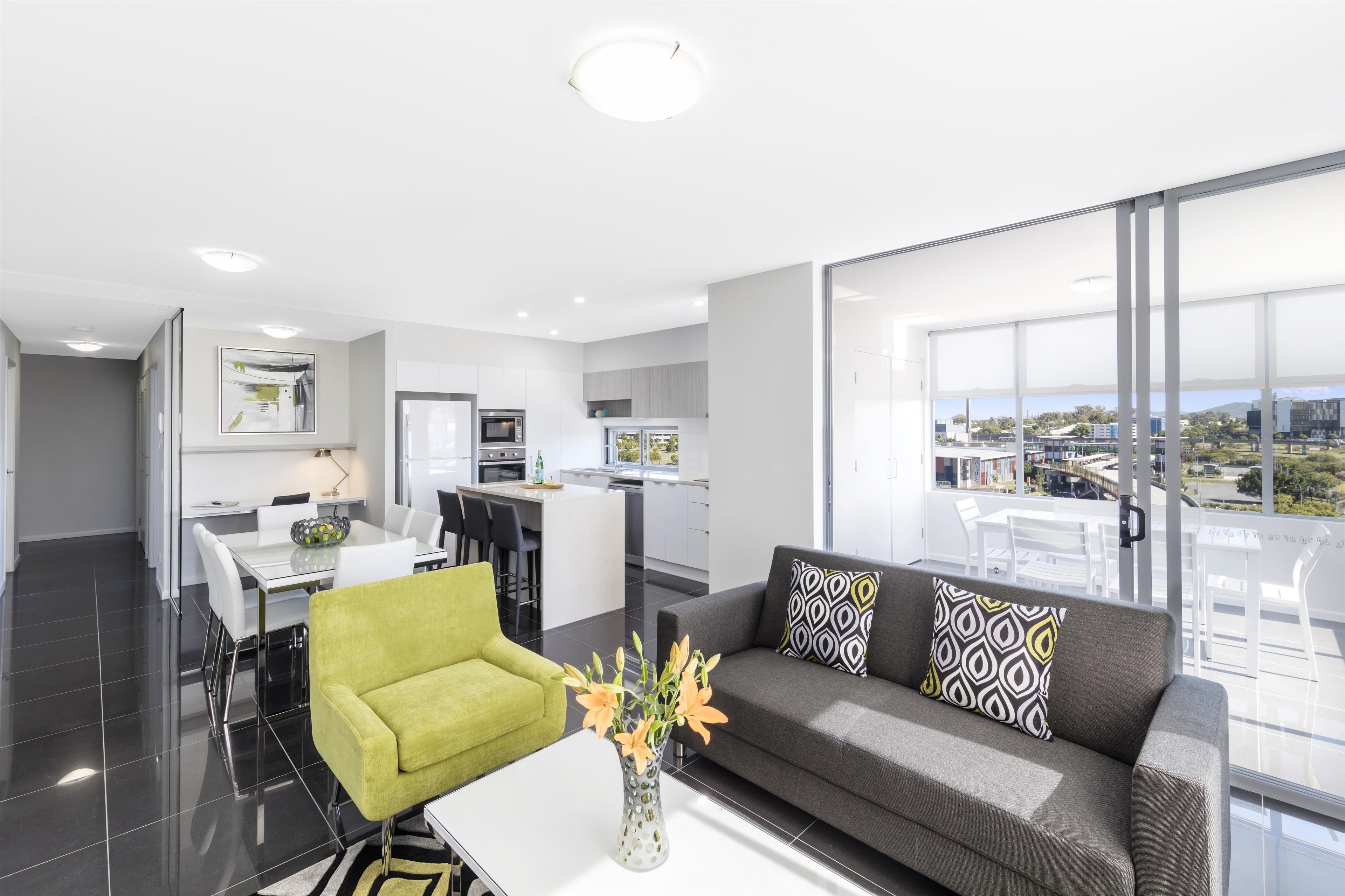 Un apartament modern amb zona de menjador, cuina i un balcó amb vista a la ciutat.