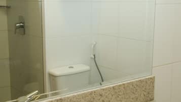 Un baño con lavabo, espejo y perchero para toallas.