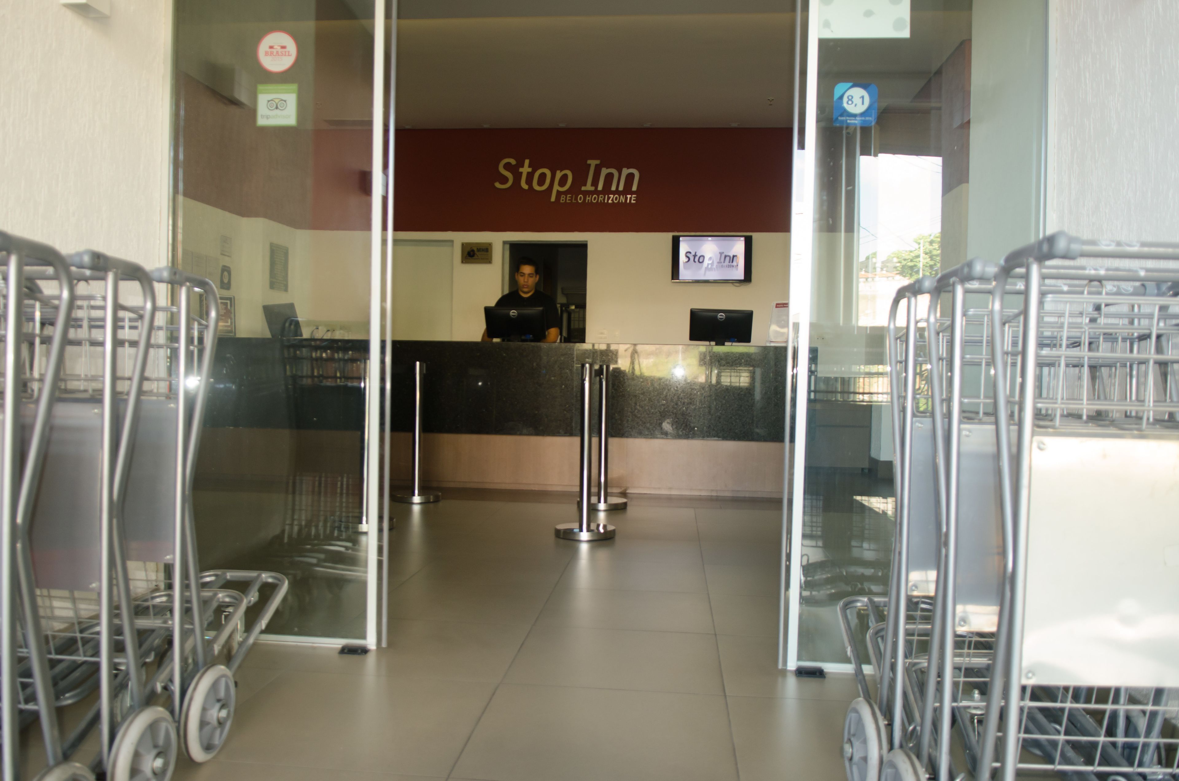 A reception area with a 'Stop Inn' sign, a receptionist, and several shopping carts.