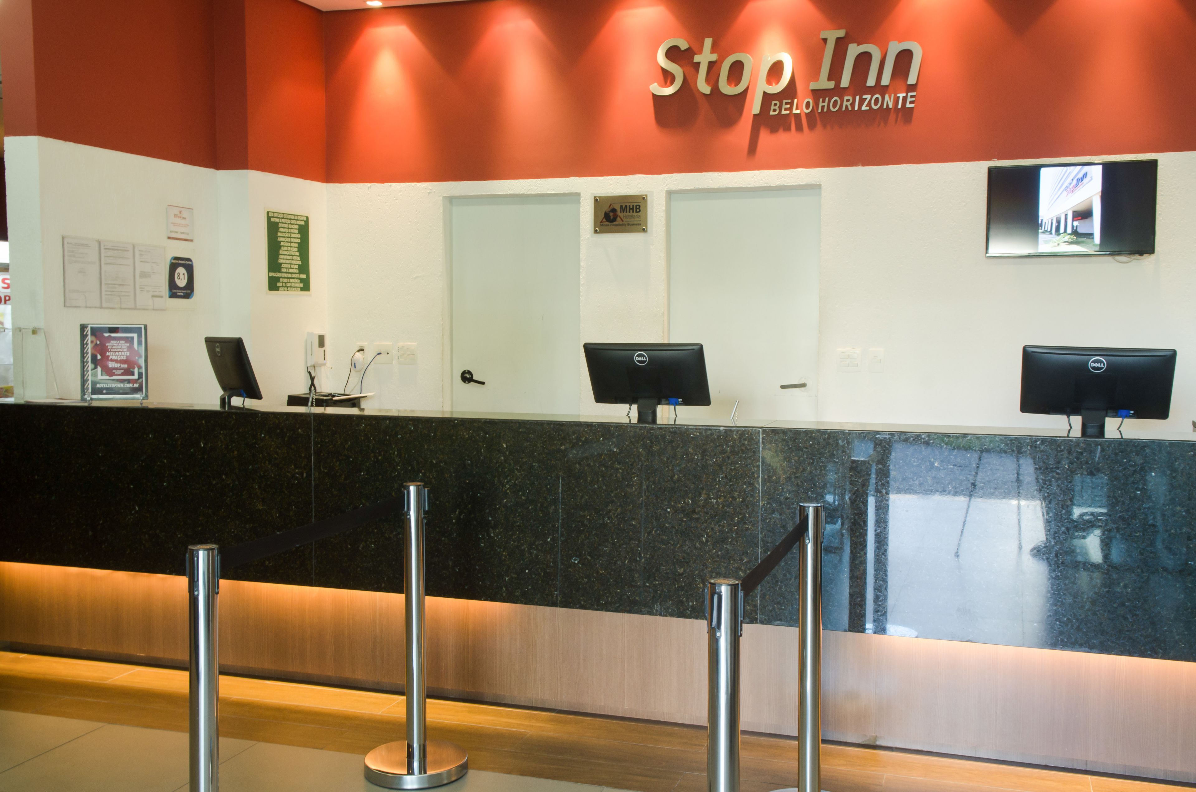 Una mesa de recepción en un hotel con un letrero que dice "Stop Inn Bello Horizonte".