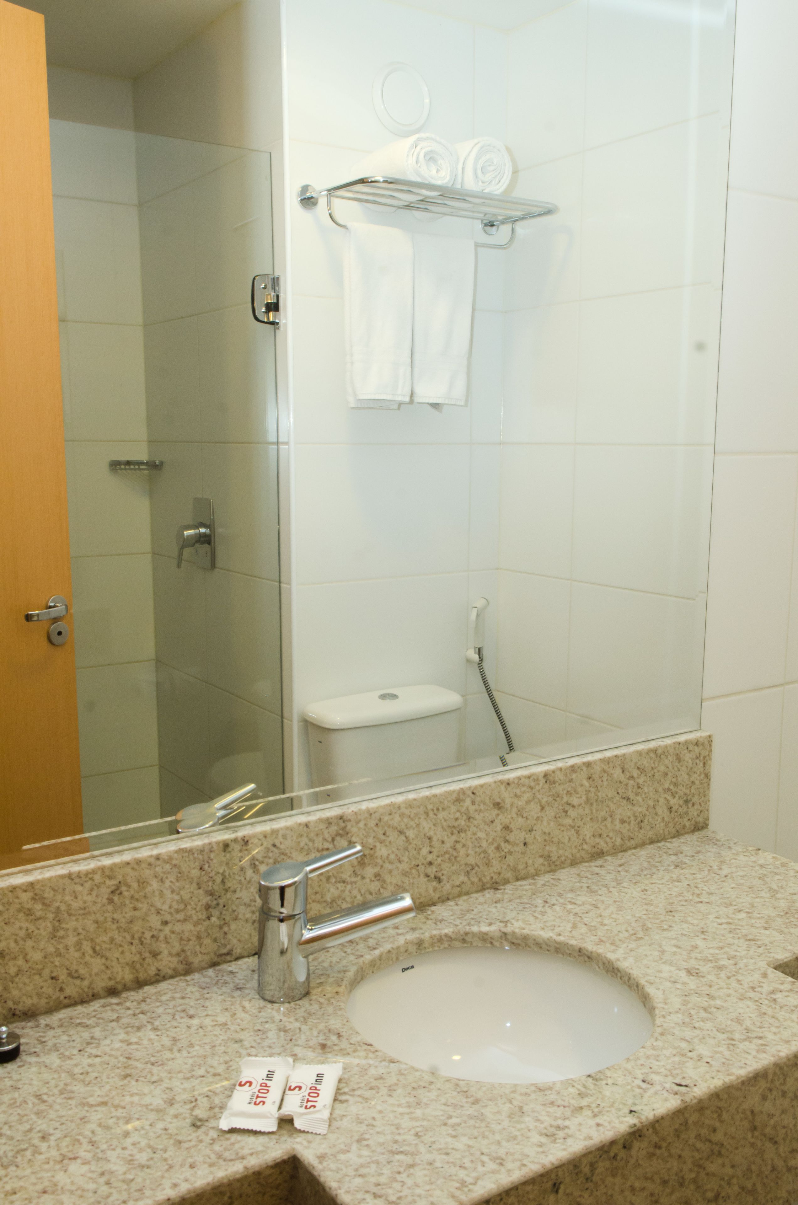 A bathroom with a sink, mirror, and towel rack.
