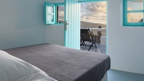 Ein Schlafzimmer mit einem Bett, einem Fenster mit Blick auf eine Berglandschaft und einer Tür zu einem Außenbereich mit einem Fahrrad.