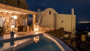 Un edificio moderno con fachada de piedra y una zona de piscina.