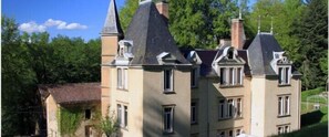 Un grand bâtiment historique doté de nombreuses tours, dont une tour centrale particulièrement imposante.